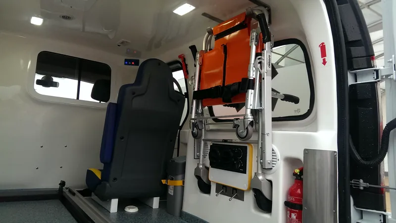 Wnętrze Renault Kangoo z krzesełkiem transportowym na ścianie