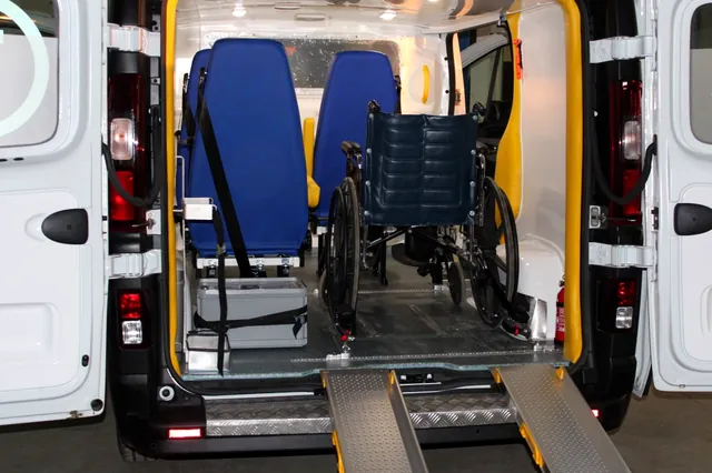Renault Trafic z rampą najazdową i wózkiem inwalidzkim w przedziale